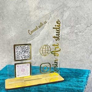 acrylic qr code stand on a white desk displaying custom Twitter and WhatsApp codes.