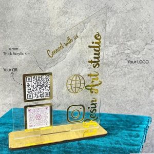 A see-through acrylic qr scanner stand placed on a corporate reception desk for visitor check-in.