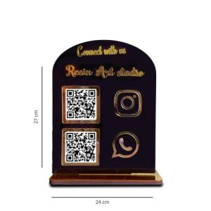 Gold mirror qr code stand placed on a marble counter inside a high-end fashion boutique displaying a payment code.