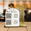 A white acrylic social media qr code stand on a desk displaying custom Instagram and Google Pay codes.
